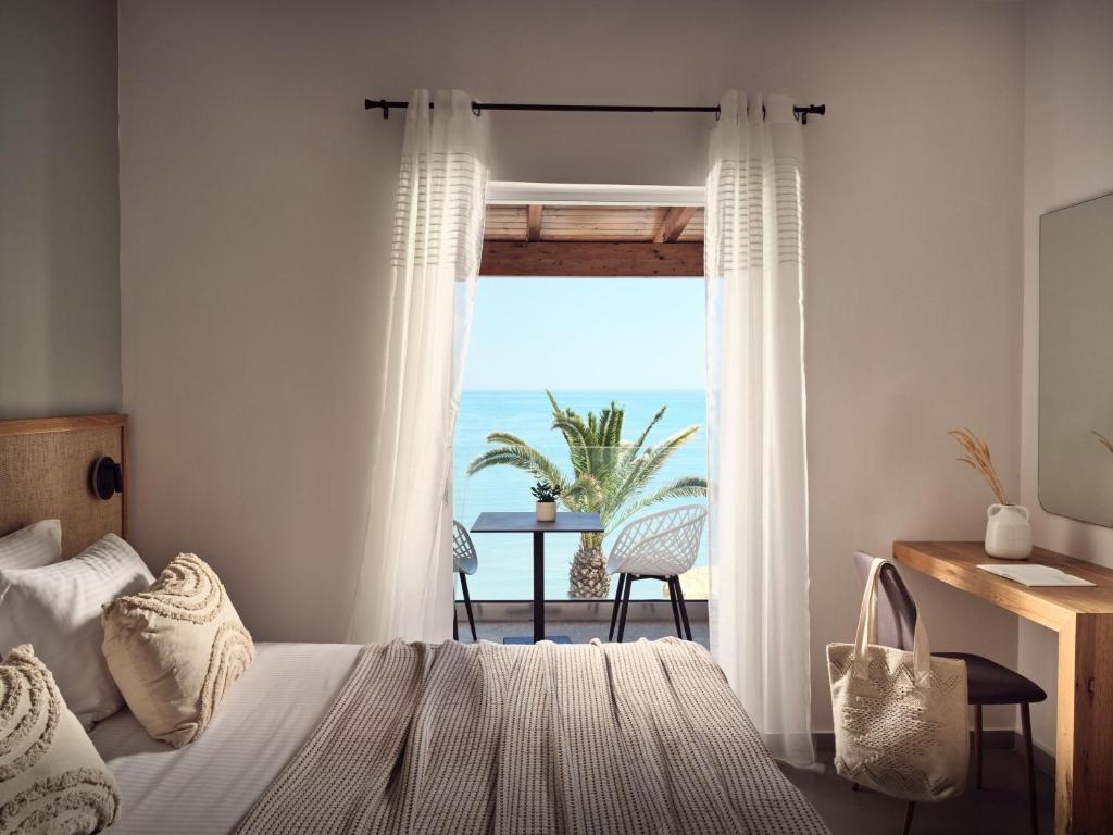 a bedroom with a bed and a view of the ocean at Villa Grimani in Laganas