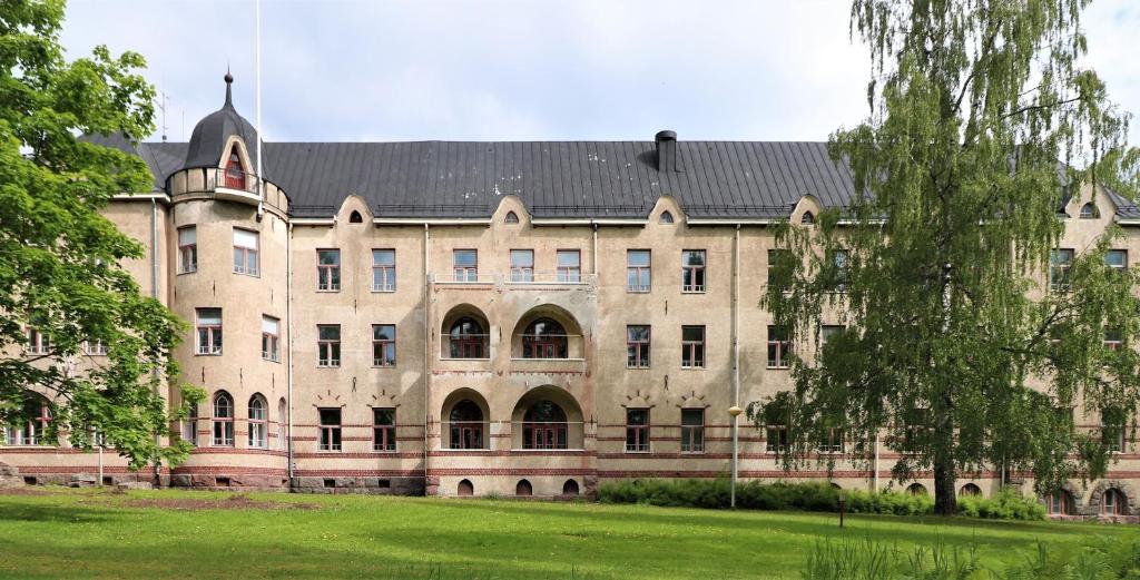 ein großes Steingebäude mit schwarzem Dach in der Unterkunft Forenom Hostel Röykkä in Helsinki