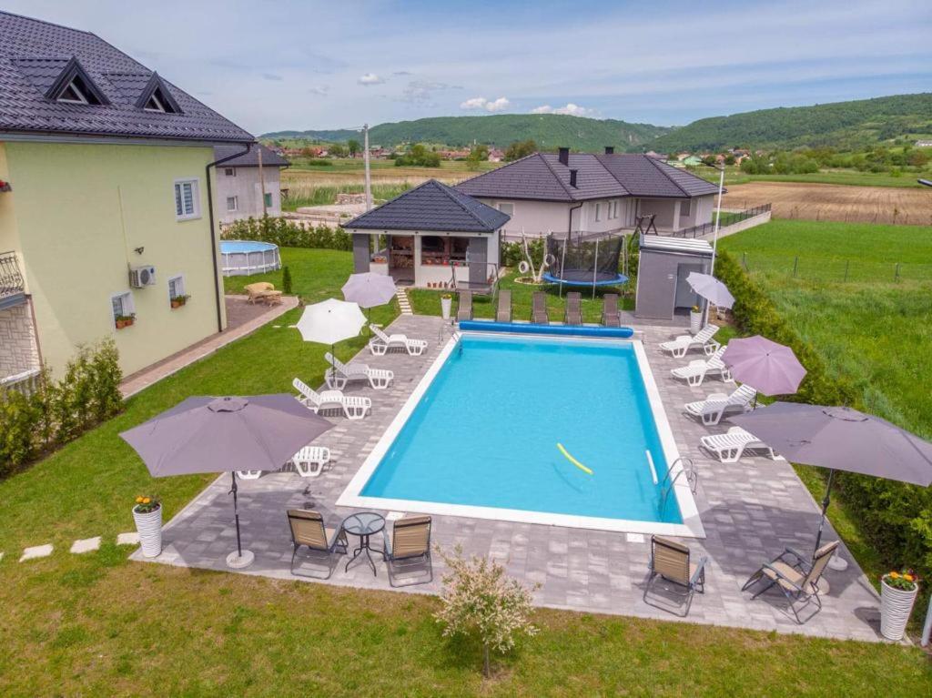una vista dall'alto di una piscina con sedie e ombrelloni di City villa Bihac a Bihać