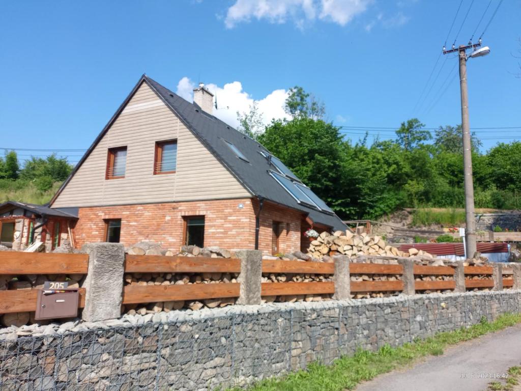 uma casa de tijolos atrás de uma cerca de pedra em Apartmán Dobrná 