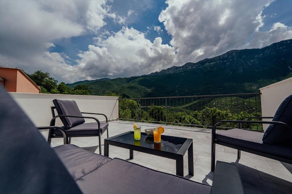 einen Balkon mit 2 Stühlen und einem Tisch mit Aussicht in der Unterkunft Apartman Josipa in Zagvozd