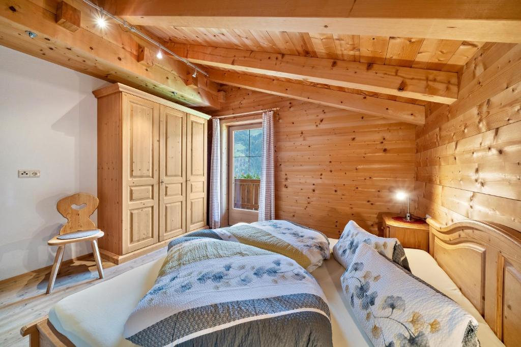 a bedroom with a bed in a log cabin at Marschalkhof Sankt Helena in Motini al Rio