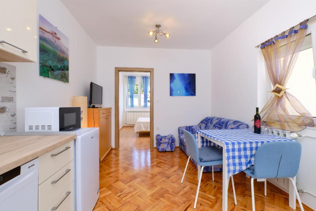 a kitchen and living room with a table and chairs at Sun in Mali Lošinj