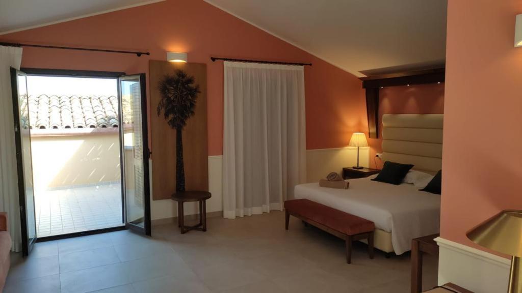 a bedroom with a bed and a large window at Firriato Hospitality - Baglio Sorìa in Trapani