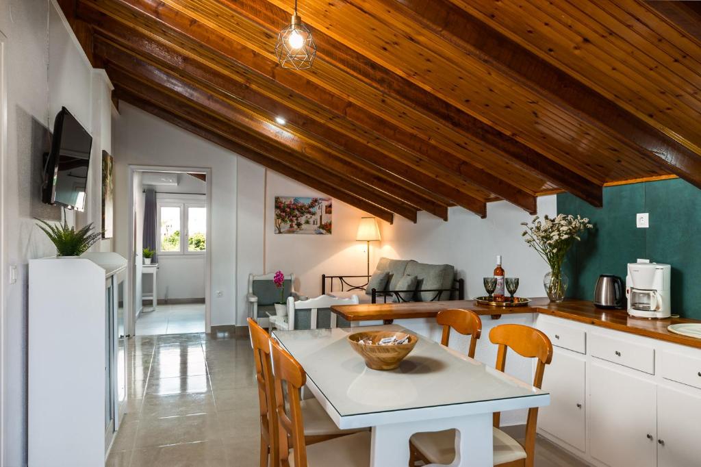 a kitchen and living room with a table and chairs at Attico Verde in Kastanéa