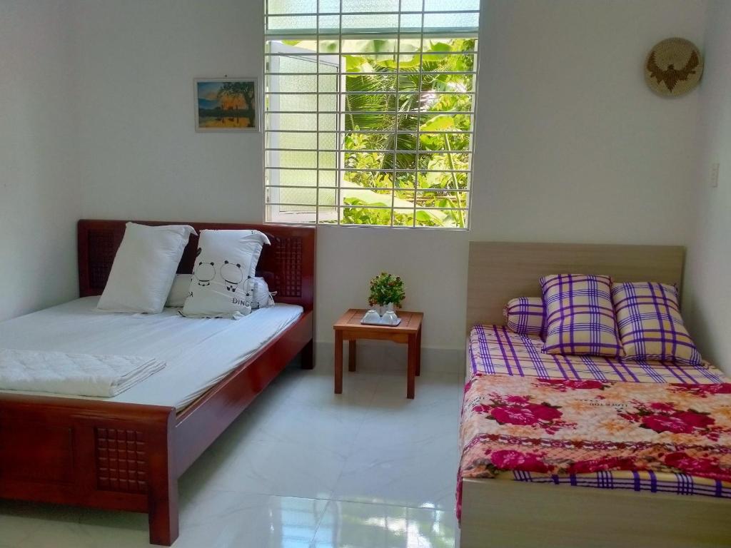 a bedroom with a bed and a couch and a window at Room in Vietnam 1 in Ben Tre