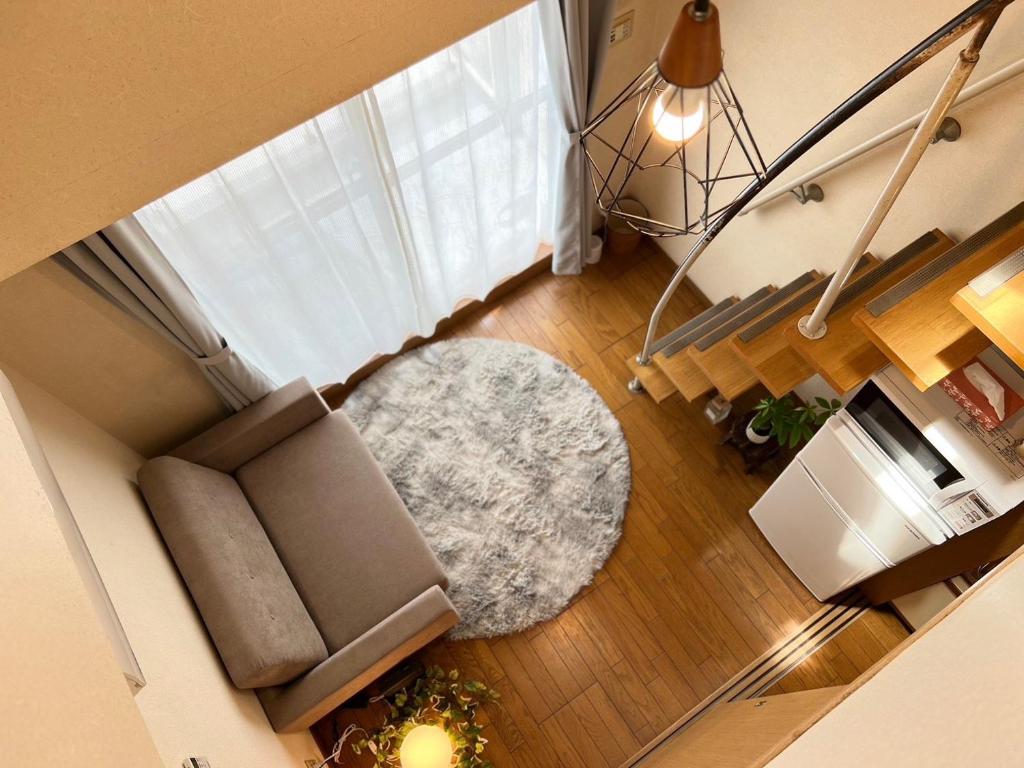 an overhead view of a living room with a couch and a rug at 東横のヨコ in Okayama