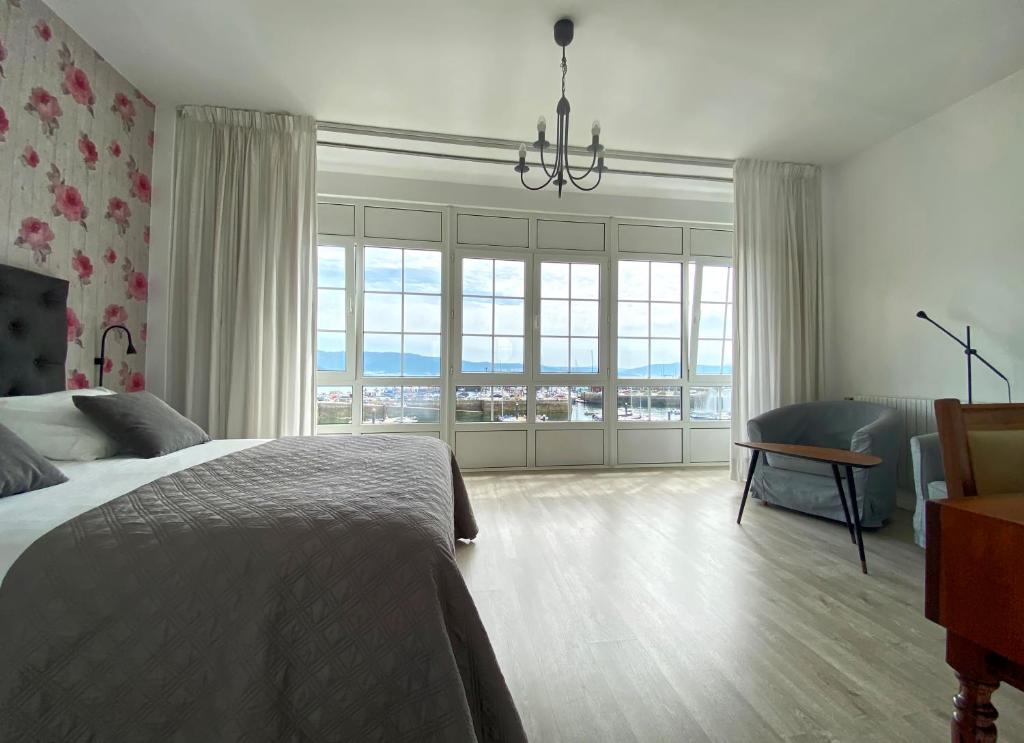 1 dormitorio con cama y ventana grande en Pensión Residencia J. Lago, en Muros