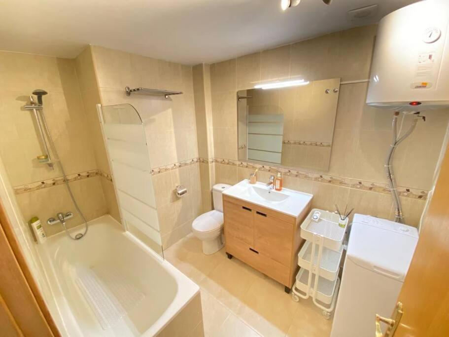 y baño con bañera, aseo y lavamanos. en Las Vistas Apartment, en Guadalest