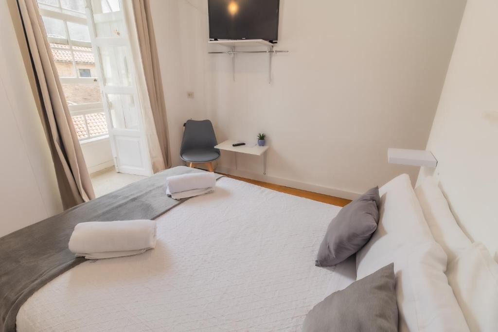 ein großes Bett in einem Zimmer mit Fenster in der Unterkunft Hostal San Pelayo in Santiago de Compostela