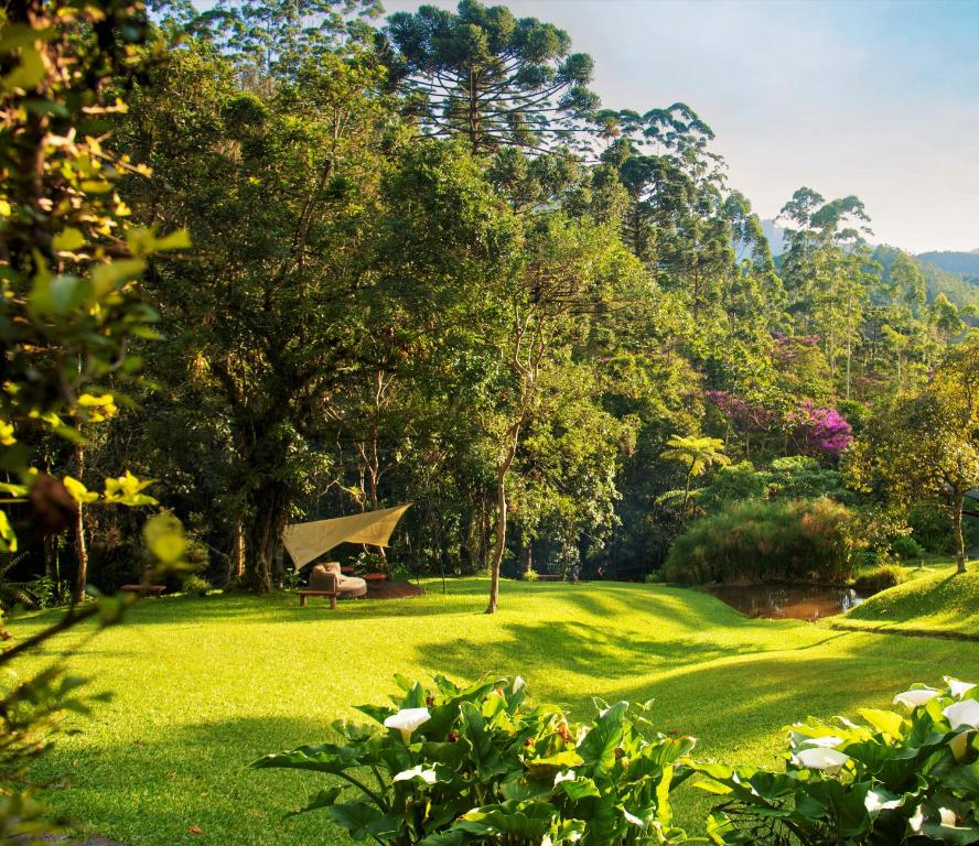 a park with a bench and trees and grass at Pousada Tijupá in Visconde De Maua