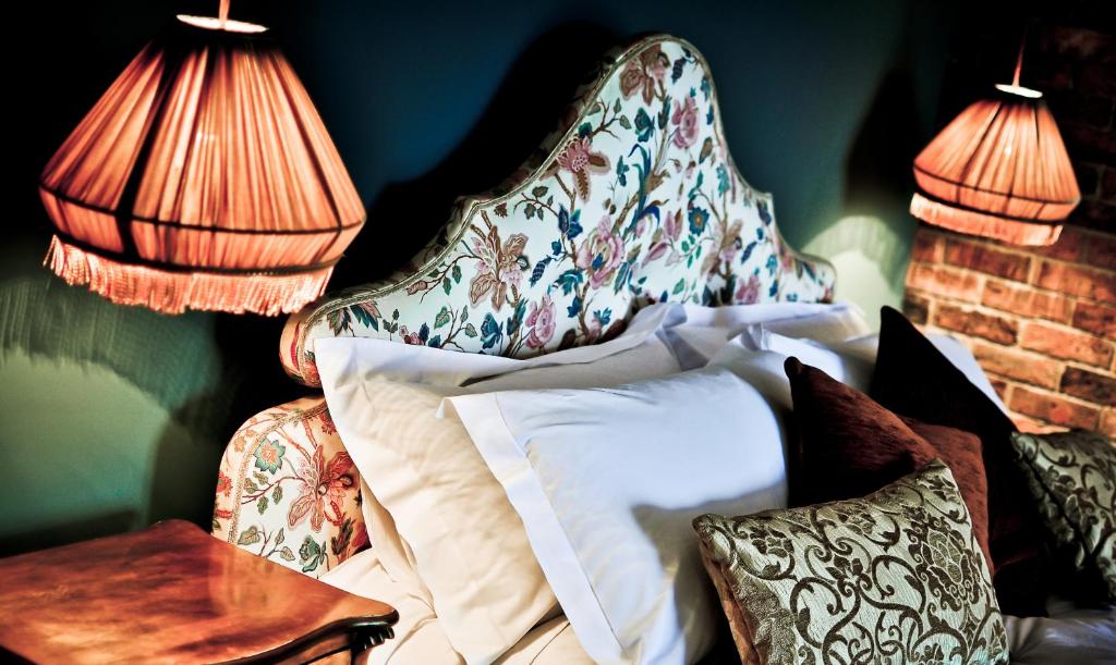 a bedroom with a bed with a headboard and pillows at The Joiners Arms in Chathill