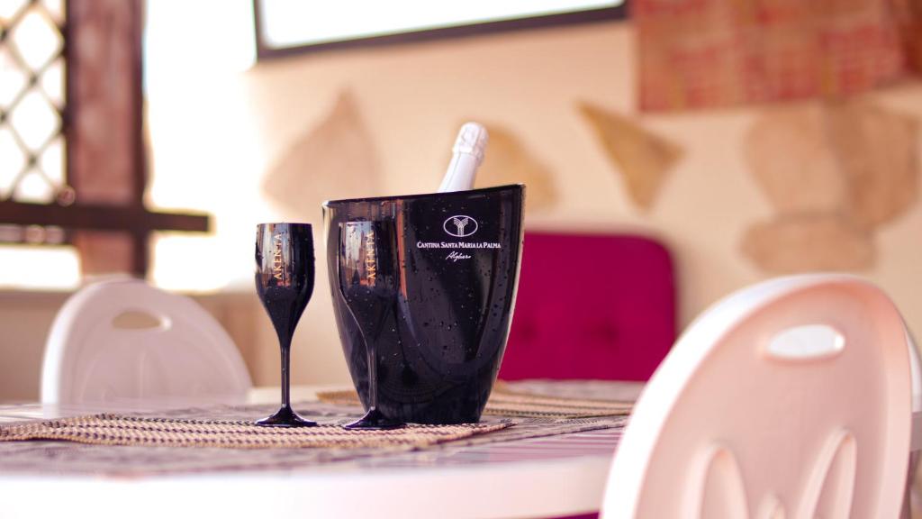 una taza negra sentada en una mesa con un cepillo de dientes en PM 12 Via Achille Grandi Guest House en Alghero