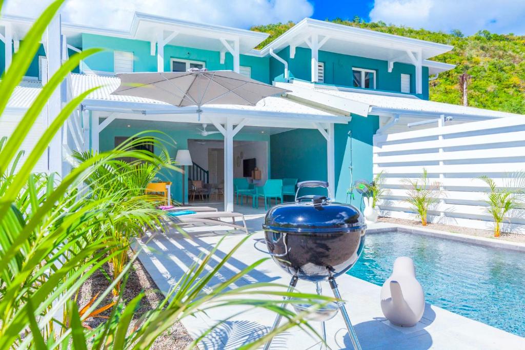 uma casa azul com um grelhador ao lado de uma piscina em Villa Océan avec piscine privée - Sun Rock ! em Le Diamant