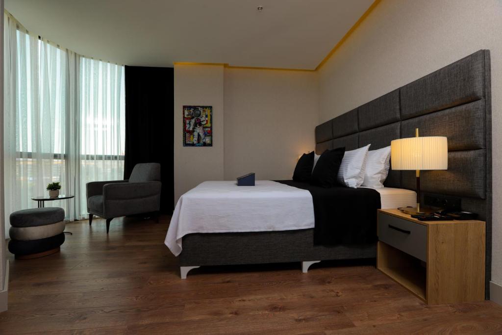 a hotel room with a large bed and a chair at Brand Business Hotel in Çorlu