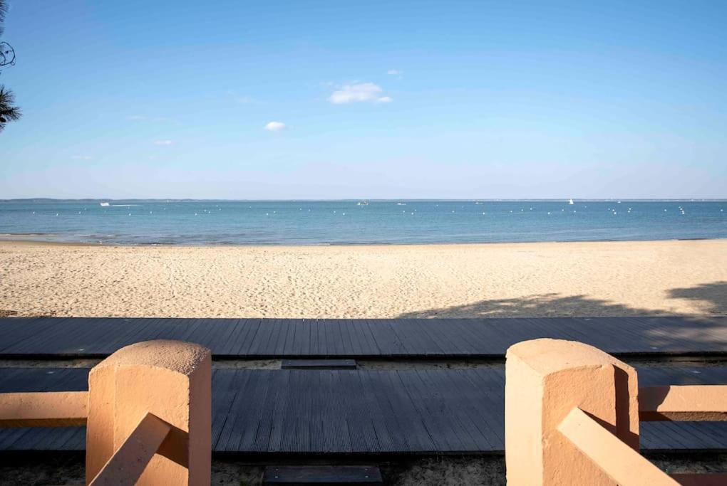 een bankje op het strand met de oceaan op de achtergrond bij *STUDIO*VUE BASSIN*ACCES DIRECT À LA PLAGE*WIFI* in Arcachon