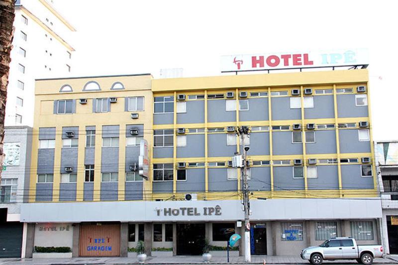 a hotel building with a car parked in front of it at Hotel Ipê in Belém