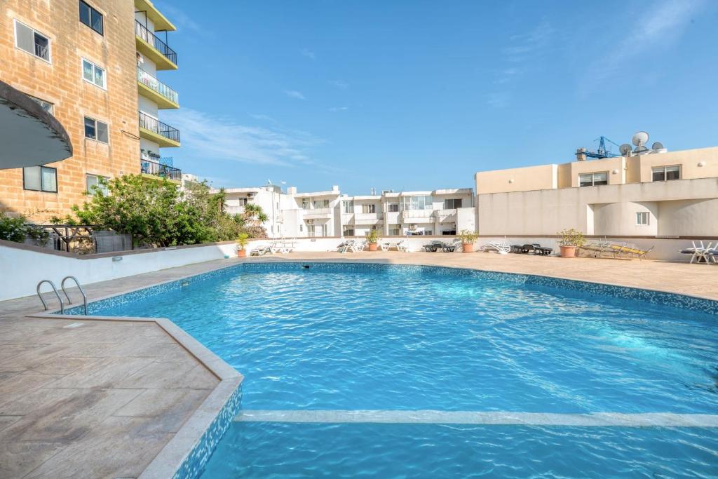 a large swimming pool in front of a building at Pool Apartment-Hosted by Sweetstay in Is-Swieqi