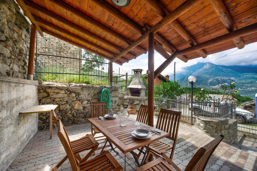 a wooden table and chairs on a patio with a view at Casa Jonathan in Saint Vincent