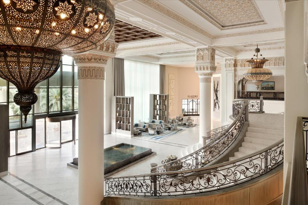 um grande átrio com uma escada e um lustre em Al Ahsa InterContinental, an IHG Hotel em Al Ahsa