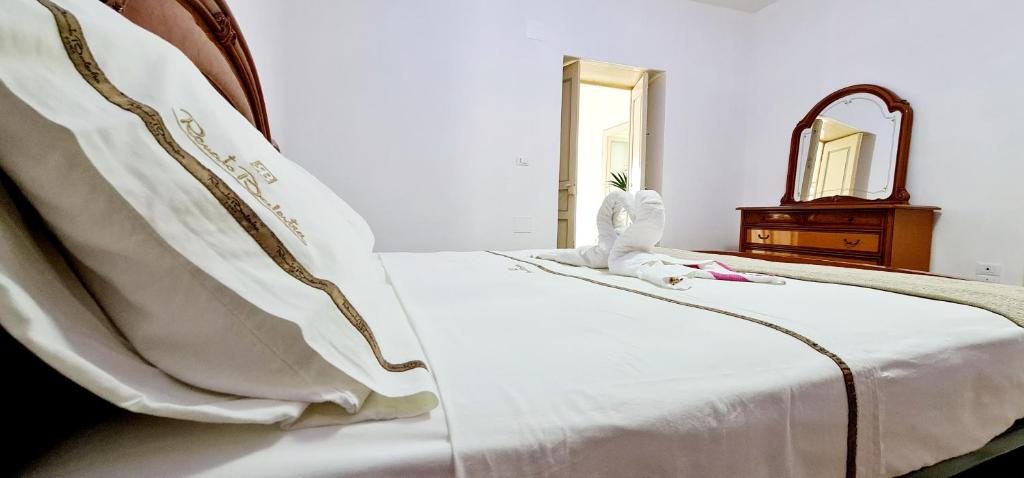 białe łóżko z wypchanym zwierzakiem. w obiekcie Torrione Maison w mieście Ischia