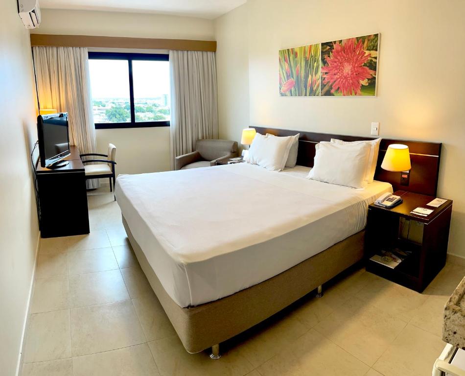 um quarto de hotel com uma cama grande e uma secretária em Hotel Saint Paul em Manaus