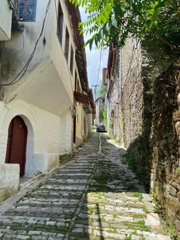 a cobblestone alley with a car parked on a street at Lula Guesthouse in Gjirokastër