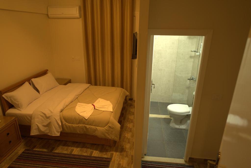 a bedroom with a bed and a bathroom with a toilet at Central Cairo Hotel in Cairo