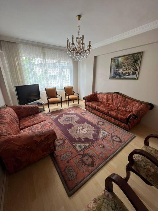 a living room with two couches and a rug at Trabzon Meydan Şehir Merkezi Trabzon City Centre in Trabzon