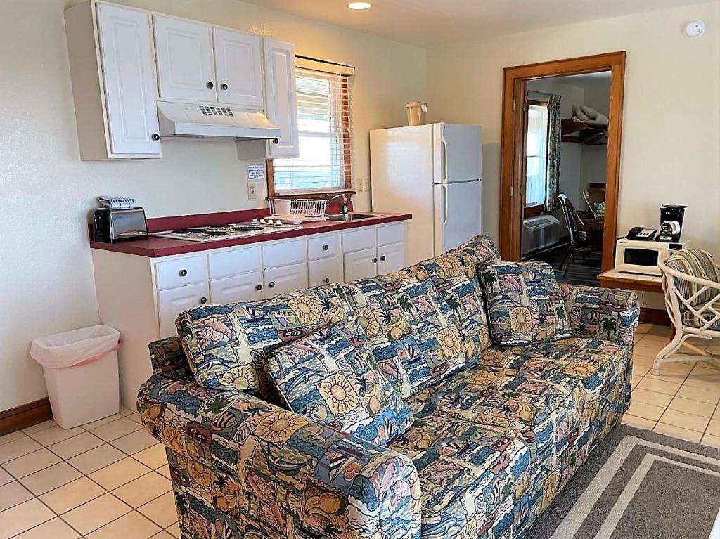 a living room with a couch and a kitchen at Pony Island Inn in Ocracoke