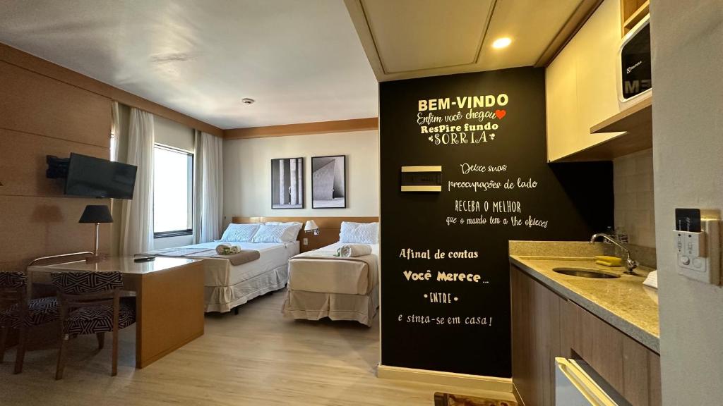 een hotelkamer met een bed, een keuken en een kamer bij NIPS 1309 - Ótimo Apto Alto do Tatuapé in Sao Paulo