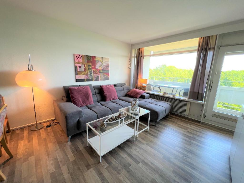 uma sala de estar com um sofá e uma mesa em Panoramic App A05-2 em Sierksdorf