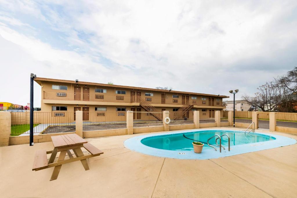eine Terrasse mit einem Pool, einer Bank und einem Gebäude in der Unterkunft Oyo Hotel San Antonio Lackland AFB Seaworld Hwy 90 W in San Antonio