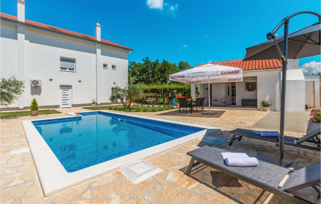 a villa with a swimming pool and a house at Beautiful Apartment In Donje Rastane in Donje Raštane