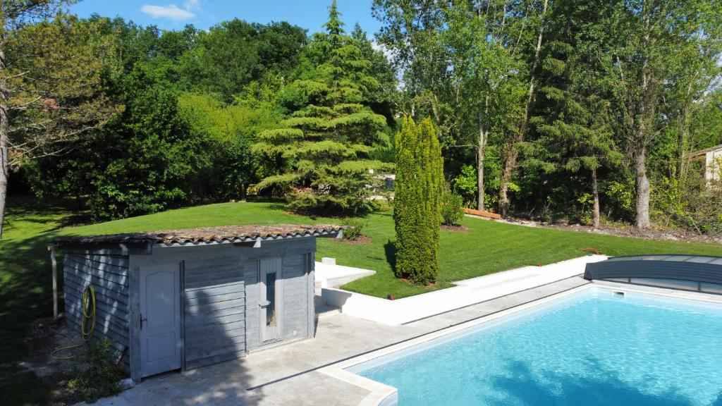 a house with a swimming pool and a shed at Chambre Lily in Parranquet