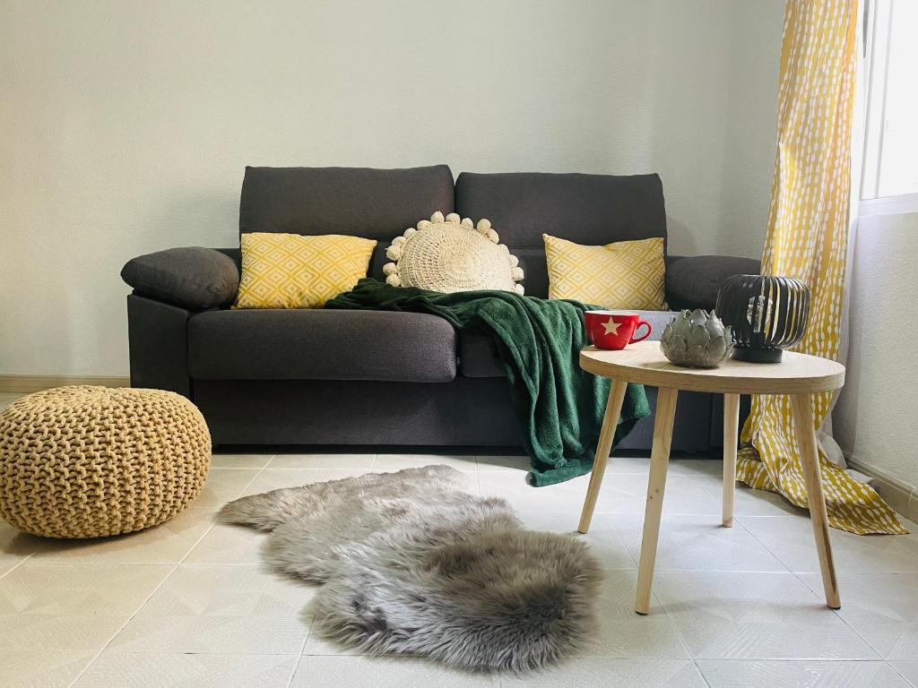 a living room with a couch and a table at Cozy 2-Bedroom Serviced Apartment with Netflix in Puerto de Sagunto