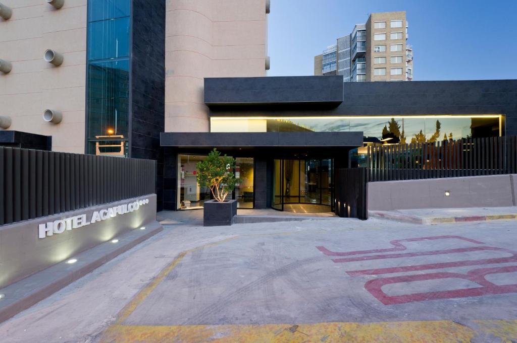 a building with a parking lot in front of it at Hotel Acapulco Benidorm in Benidorm