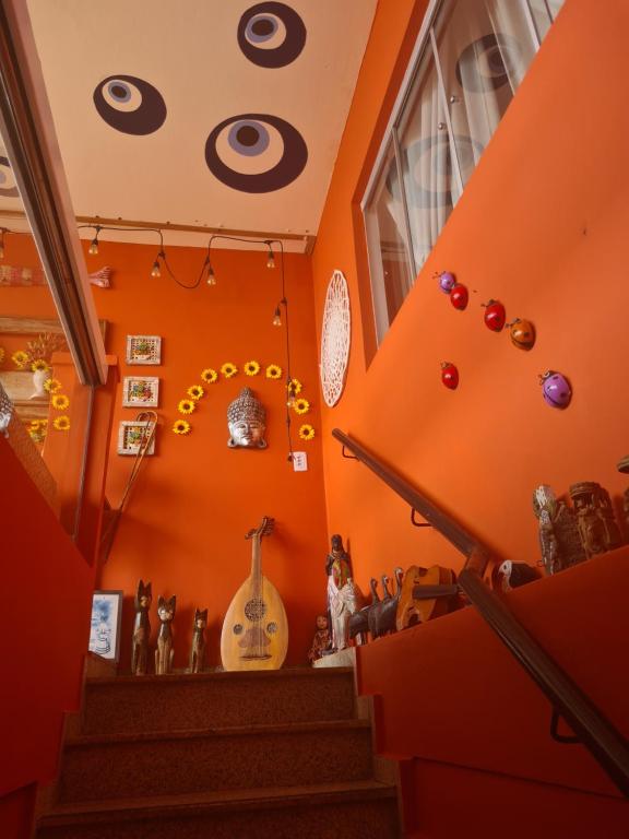 an orange room with orange walls and stairs at Kabatukila Pousada in Natal