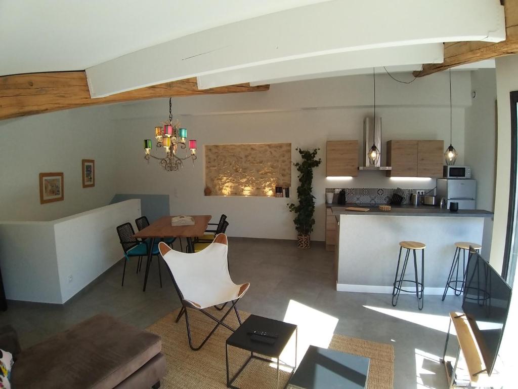sala de estar y cocina con mesa y sillas en Le Tire Bouchon, en Maraussan
