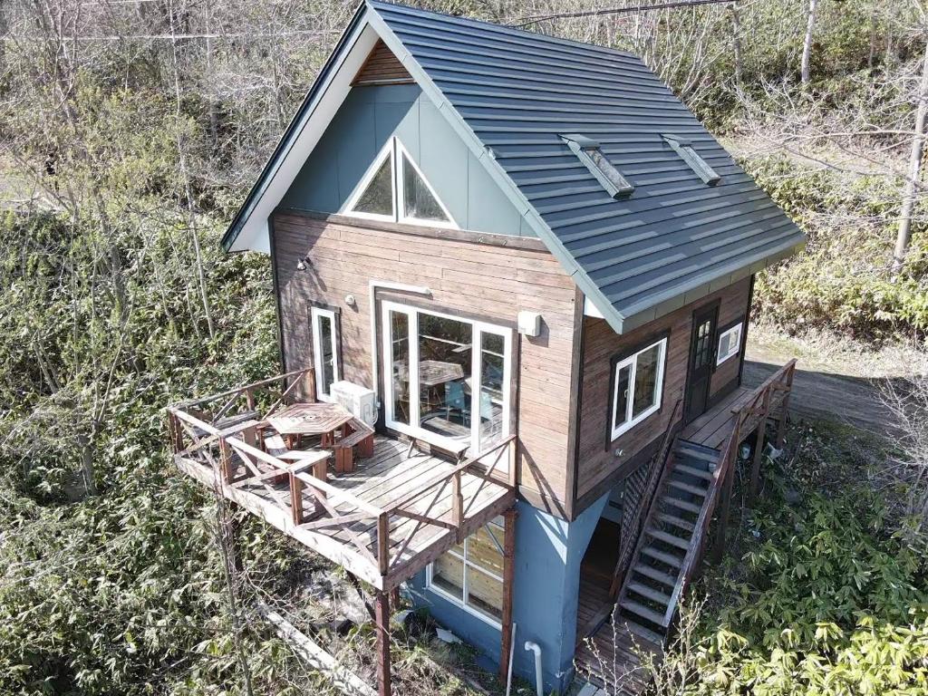una casa pequeña con porche y terraza en LAKE TOYA Great view log cabin, en Lago Toya