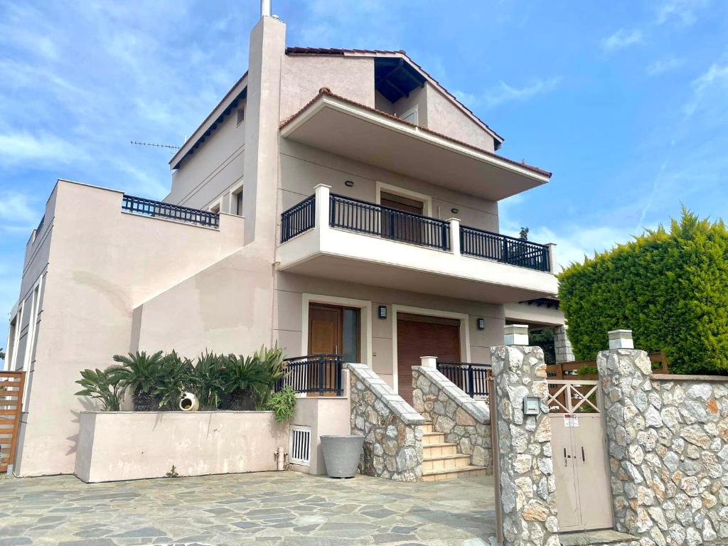 a large white house with a fence in front of it at Seaview Villa - Amazing Sea & Mountain View in Koskinou