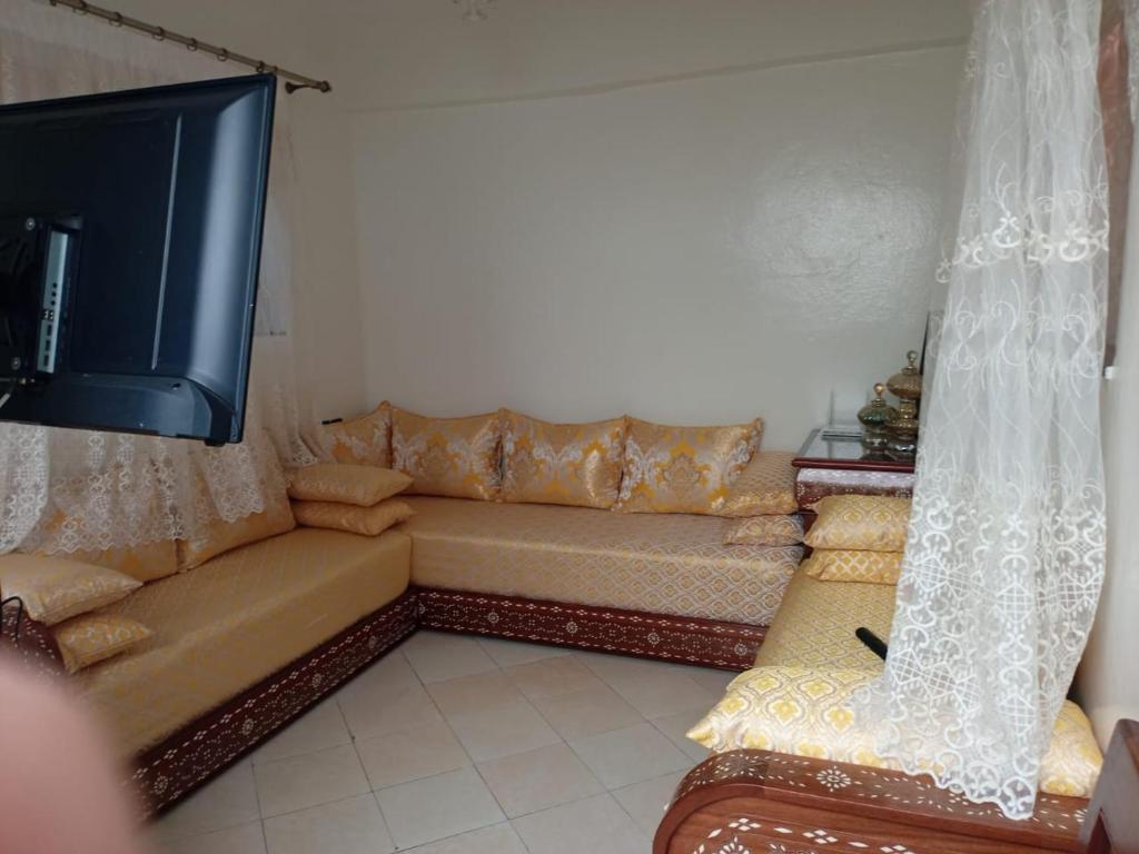 a living room with a couch and a flat screen tv at KHAOULA in Rabat