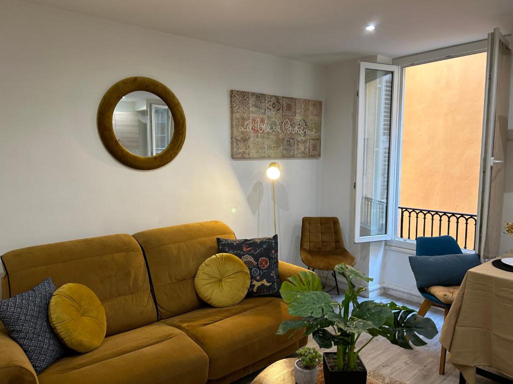 a living room with a brown couch and a mirror at studio cosy Vieux-Nice in Nice