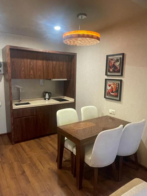 eine Küche und ein Esszimmer mit einem Tisch und weißen Stühlen in der Unterkunft Dreamland Oasis Chakvi apartment 1406 in Chakvi