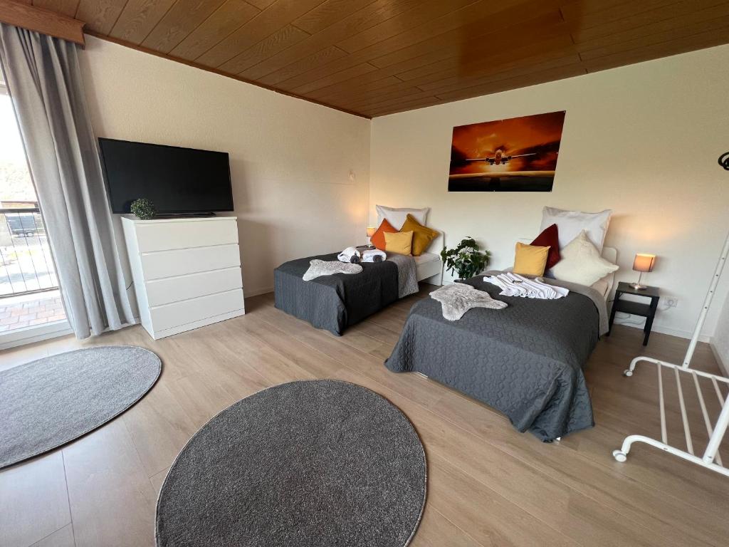 Zimmer mit 2 Betten und einem Flachbild-TV in der Unterkunft ERH03-FW Flat in Herzogenaurach in Herzogenaurach