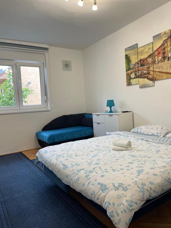 um quarto com uma cama e um sofá azul em Mona Blue em Sarajevo