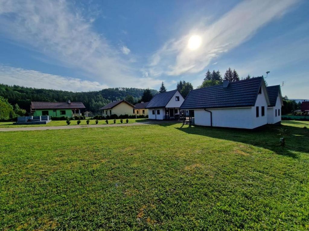 a large grass field with houses in the background at SunSet Radków in Radków