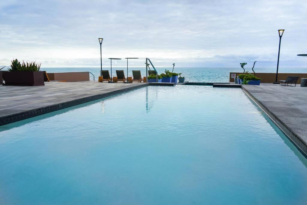 uma piscina com o oceano ao fundo em Hotel Suite Luxe Sunset em Tijuana