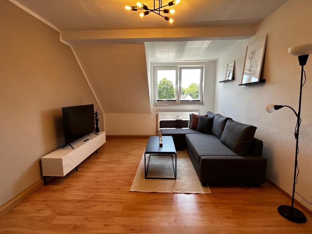 a living room with a couch and a tv at Modernes Apartment in Stadionnähe in Gelsenkirchen