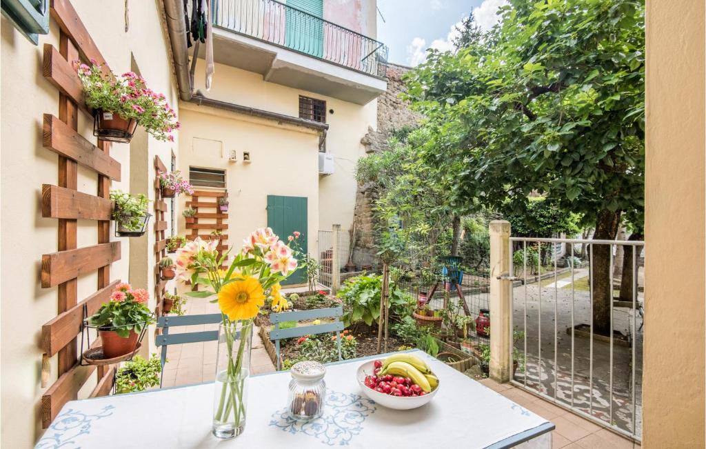 a table with a bowl of fruit and a vase of flowers on a balcony at Beautiful Apartment In Monte San Savino With 2 Bedrooms And Wifi in Monte San Savino
